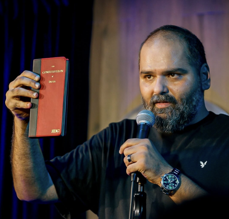 Comedian Kunal Kamra holding the copy of Constitution